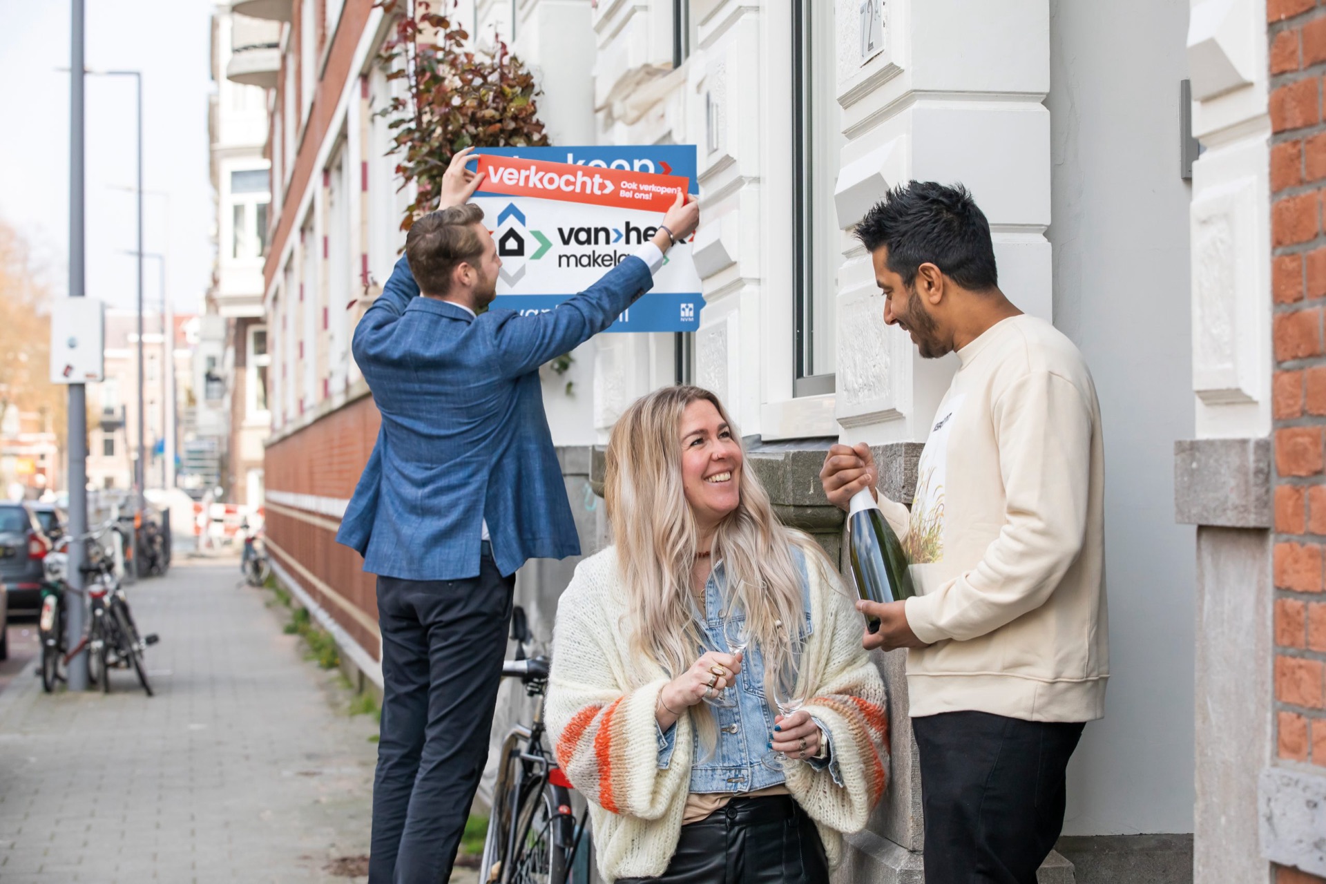 Makelaars van Van Herk hangen een verkocht-bord op bij een woning